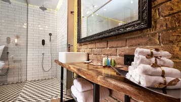 A modern bathroom with a wooden vanity, a large mirror, and a shower area with white tiles.
