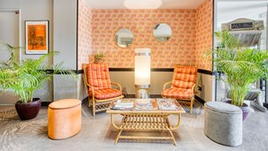 A lobby with two orange armchairs, a round table with magazines, a large floor lamp, and two potted plants. - KYRIAD BORDEAUX SUD - Villenave d'Ornon (Villenave-d'Ornon)