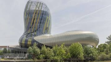 Un edificio de arquitectura moderna con un diseño curvo distintivo, ubicado cerca de una masa de agua.