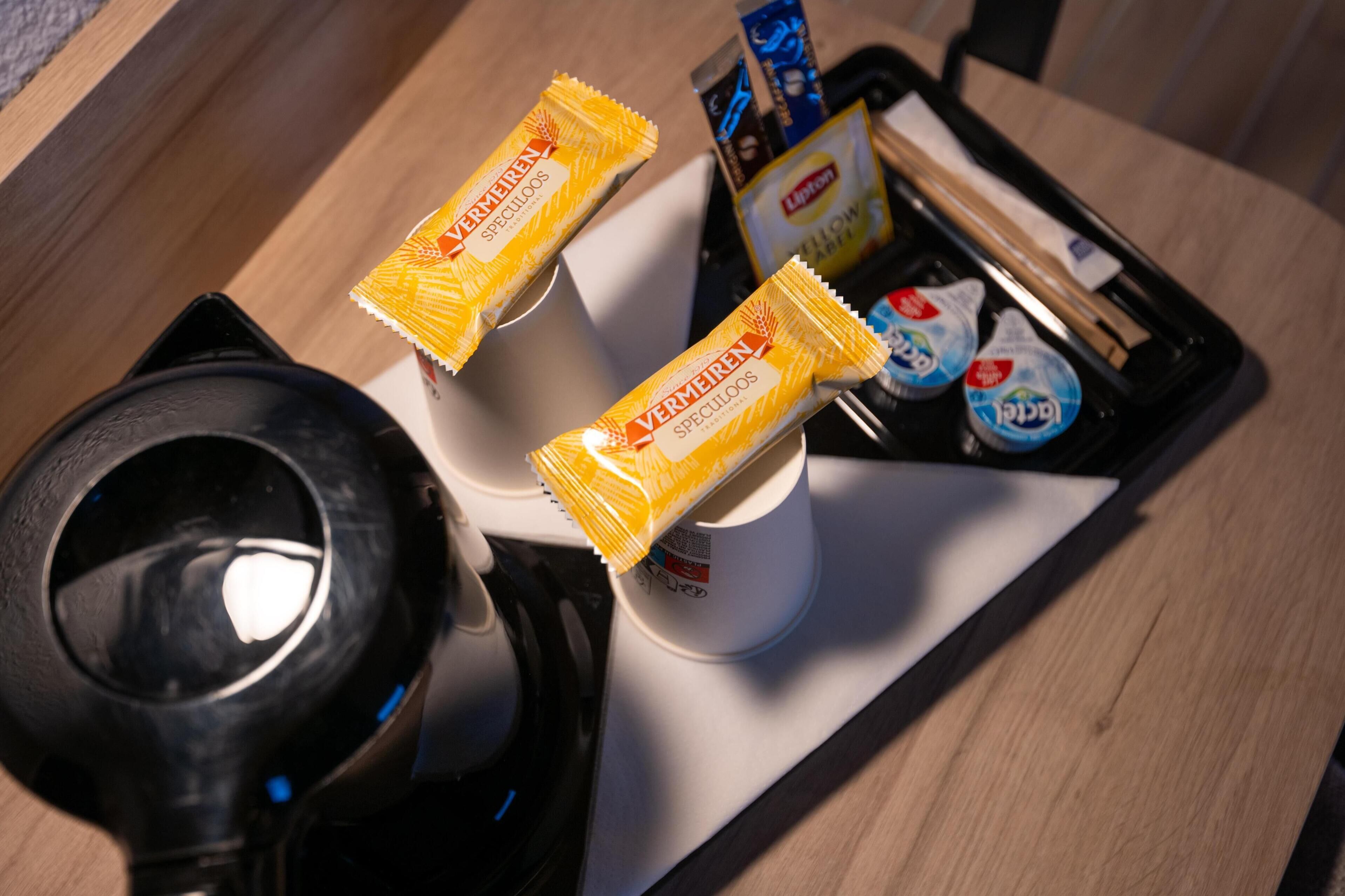 Una cafetera y dos paquetes de galletas Speculoos Vermeren sobre una bandeja.