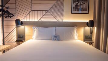 A neatly made bed with white linens, a headboard with a geometric pattern, and two bedside lamps.