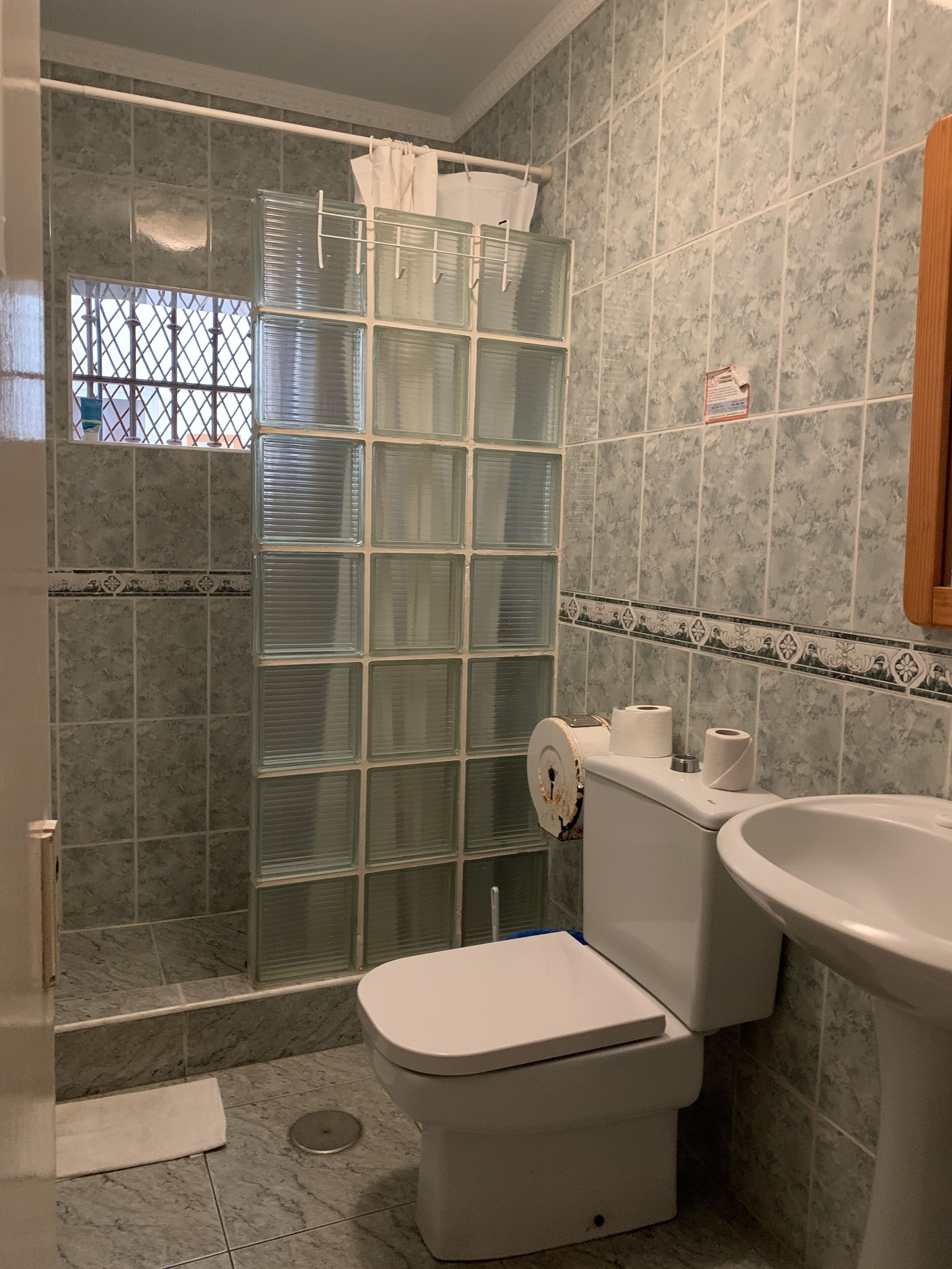 Ein Badezimmer mit Dusche, Toilette und Waschbecken.