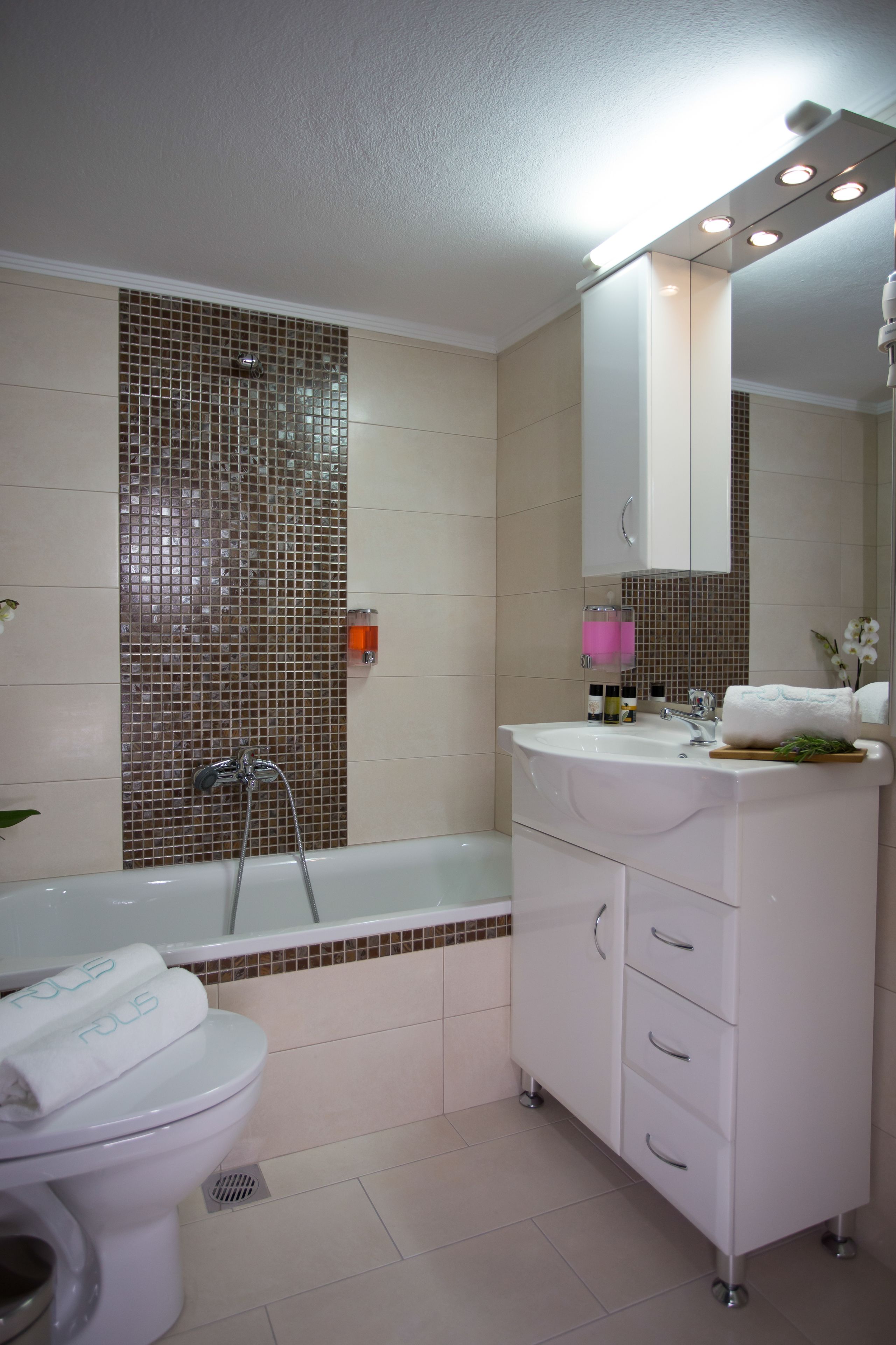 Een badkamer met toilet, wastafel en bad.
