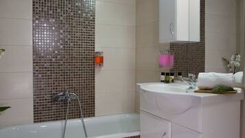 Une salle de bain avec des toilettes, un lavabo et une baignoire.