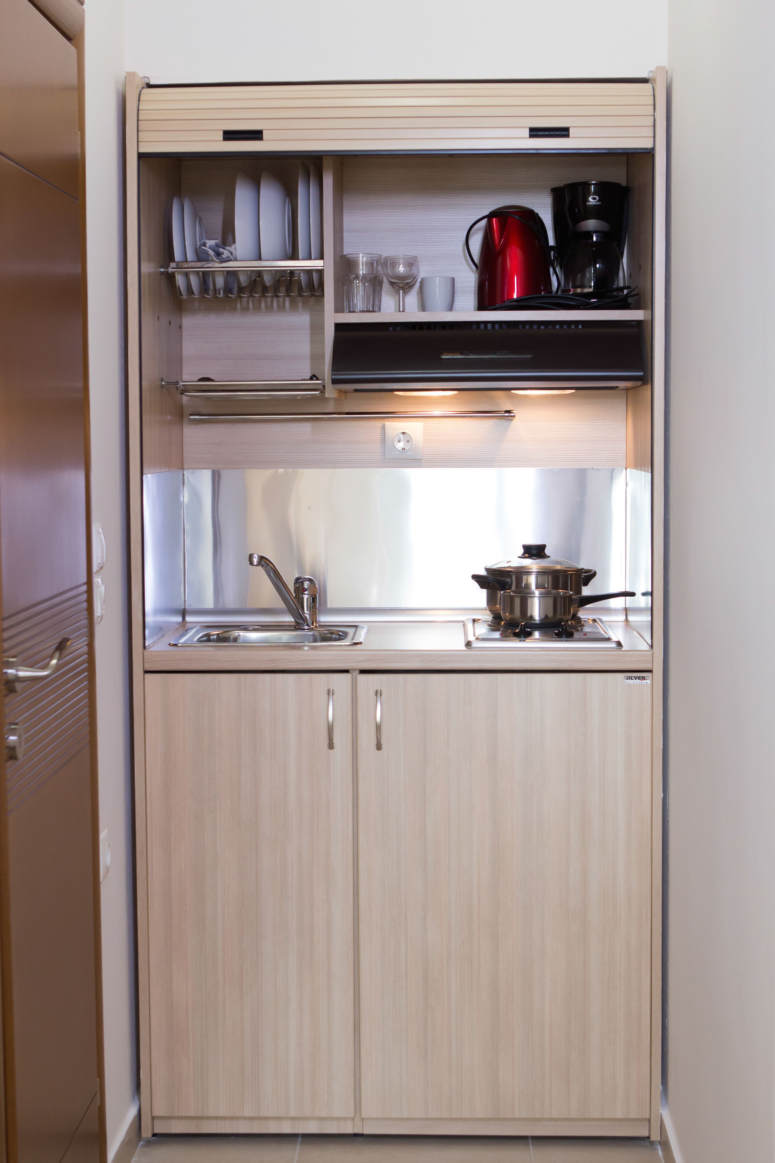 A compact kitchenette with a sink, a stove, and a small countertop.