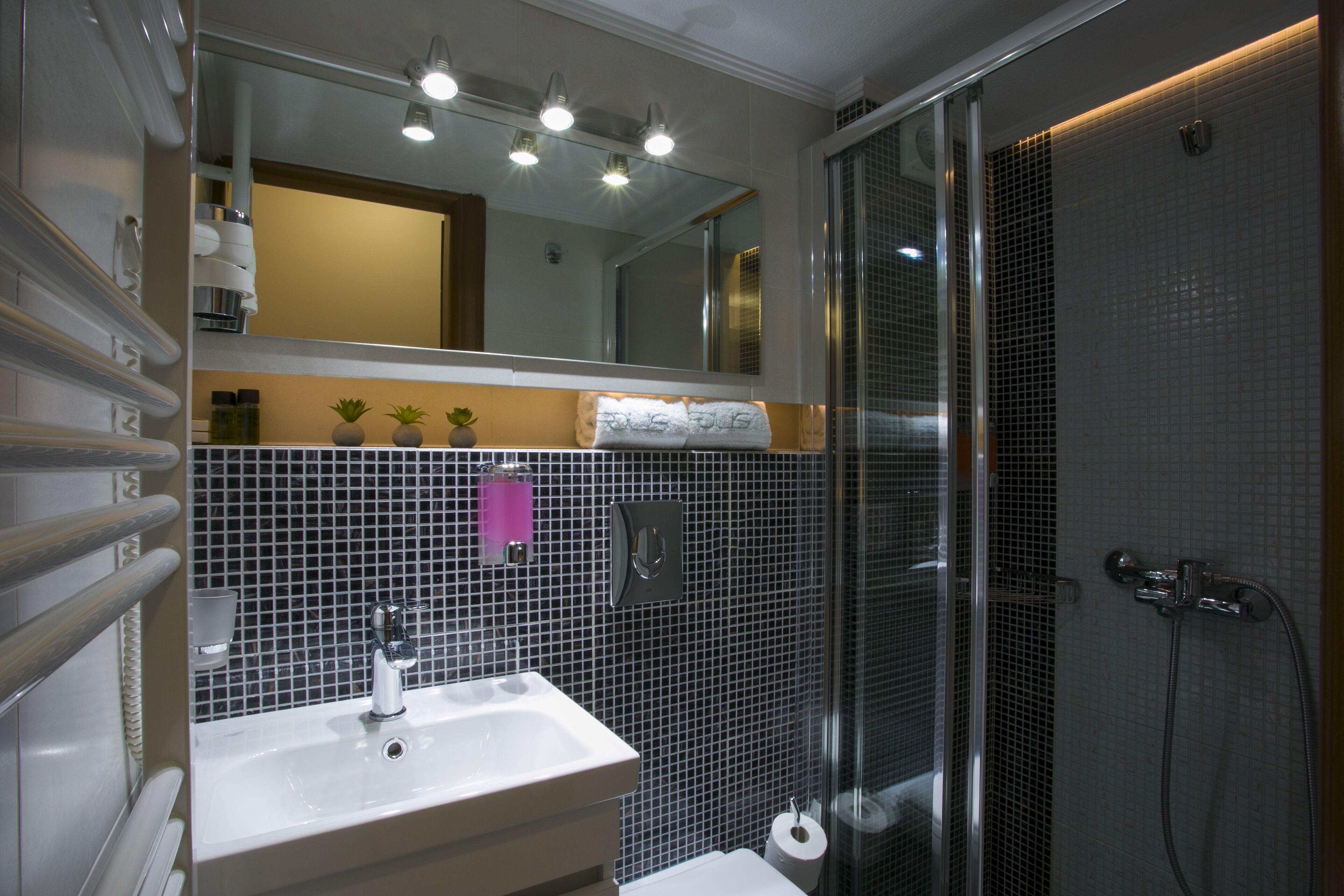 Un baño con lavamanos, espejo y ducha.