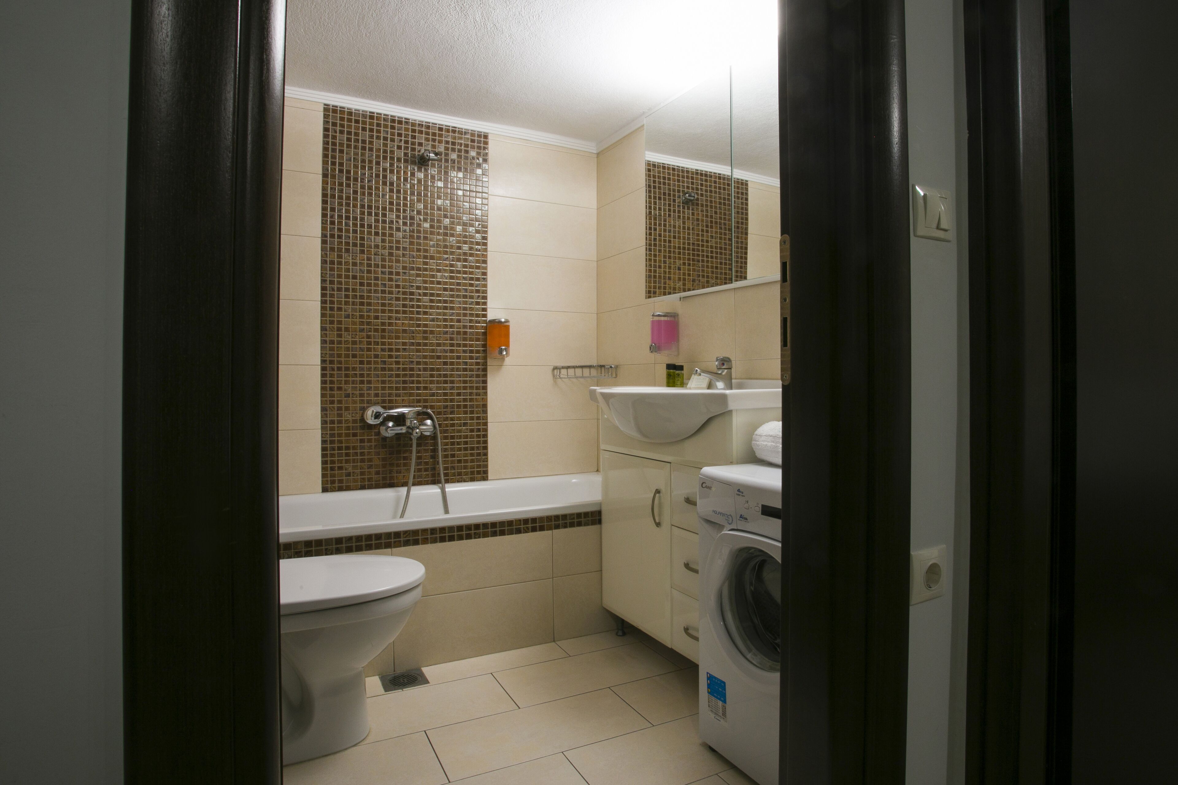 A bathroom with a toilet, sink, and washing machine.
