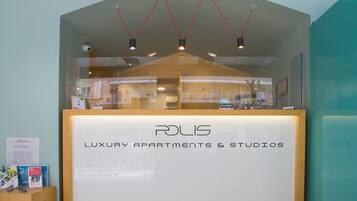 A reception desk with a sign reading "Luxury Apartments & Studios" and a modern design with pendant lights.