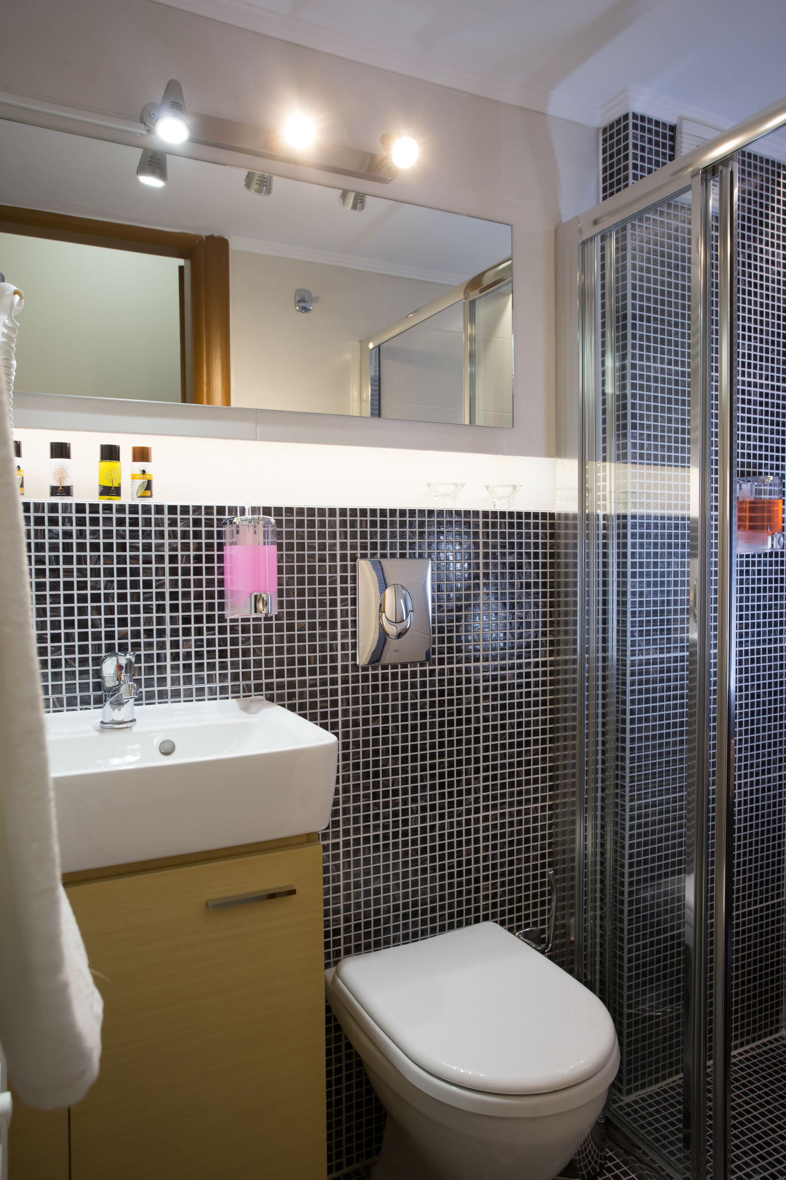 Une salle de bain avec un lavabo blanc, des toilettes et une douche à parois de verre.