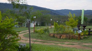 Un paysage rural avec un chemin de terre, un petit bâtiment et un kiosque.