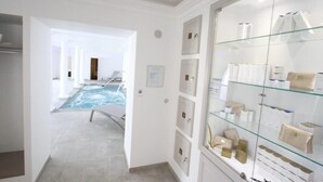 Une chambre d’hôtel dotée d’une vitrine où sont exposés les articles de toilette, d’un espace spa avec piscine, et offrant une vue sur la piscine.