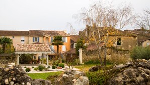 Une villa de style méditerranéen traditionnel, dotée d’un toit en tuiles, d’un patio couvert et d’un jardin bien entretenu.