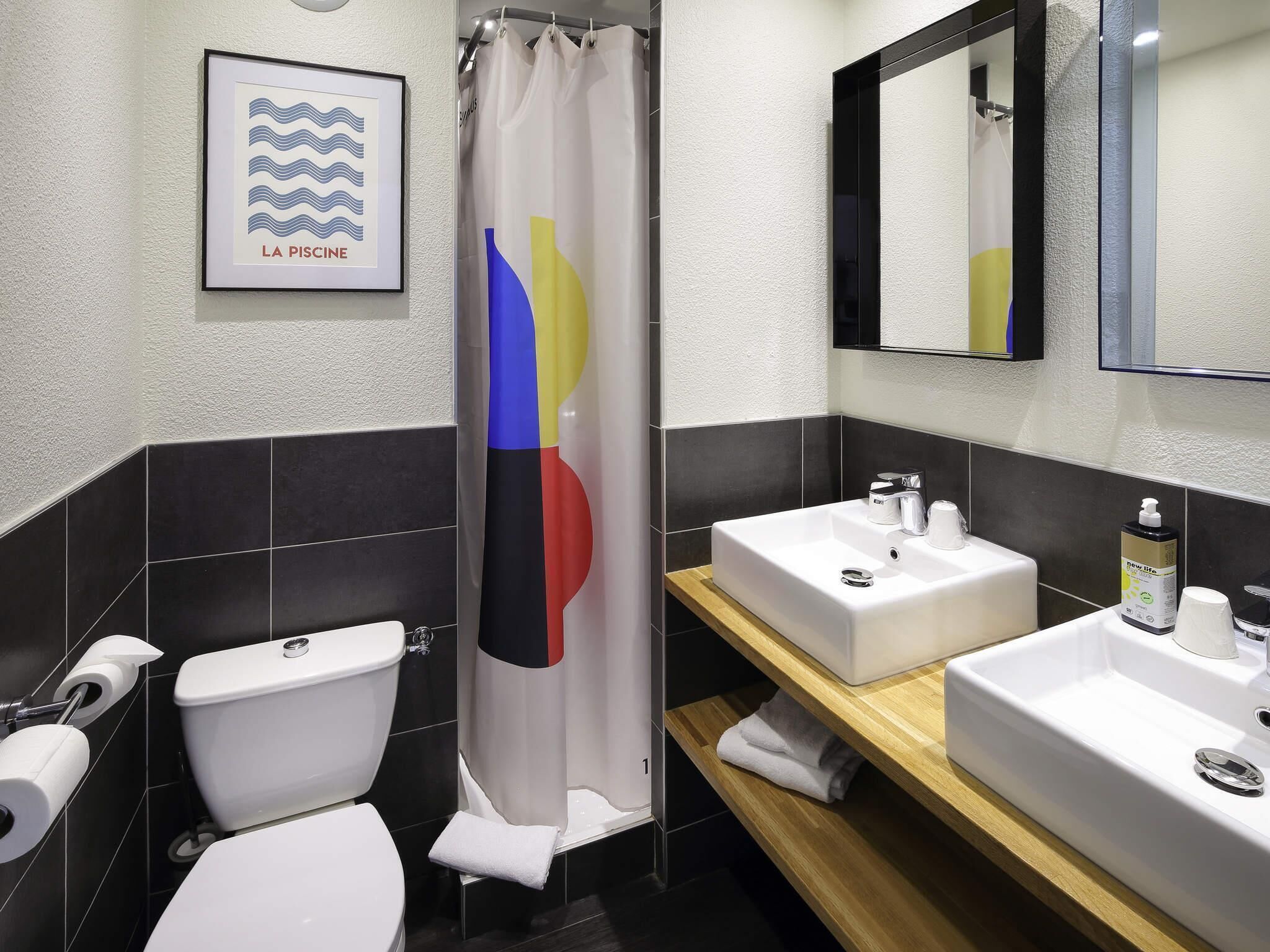 Ein modernes Badezimmer mit Toilette, Waschbecken und Duschvorhang.