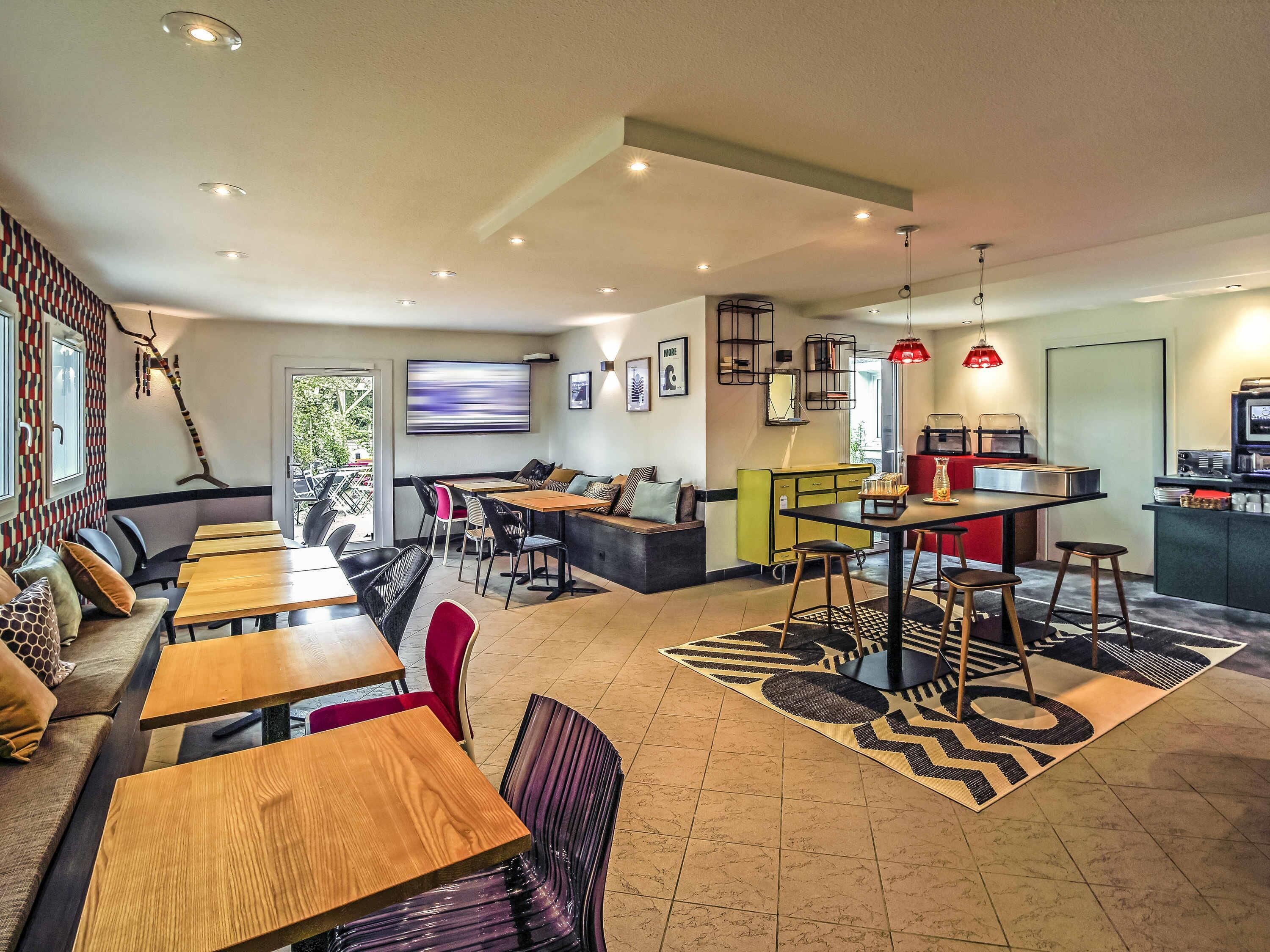 Un interior moderno con comedor, asientos y kitchenette.