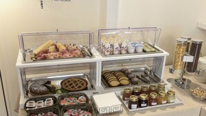 A buffet with various food items including pastries, sandwiches, and condiments. - Dimora Novecento (Catania)