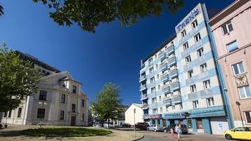 A hotel with a blue and white facade, multiple floors, and balconies.