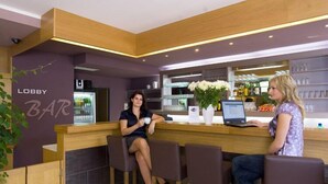 A lobby area with a reception desk, bar area, and seating.