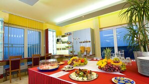A buffet setup with various food items and a large window with a view.