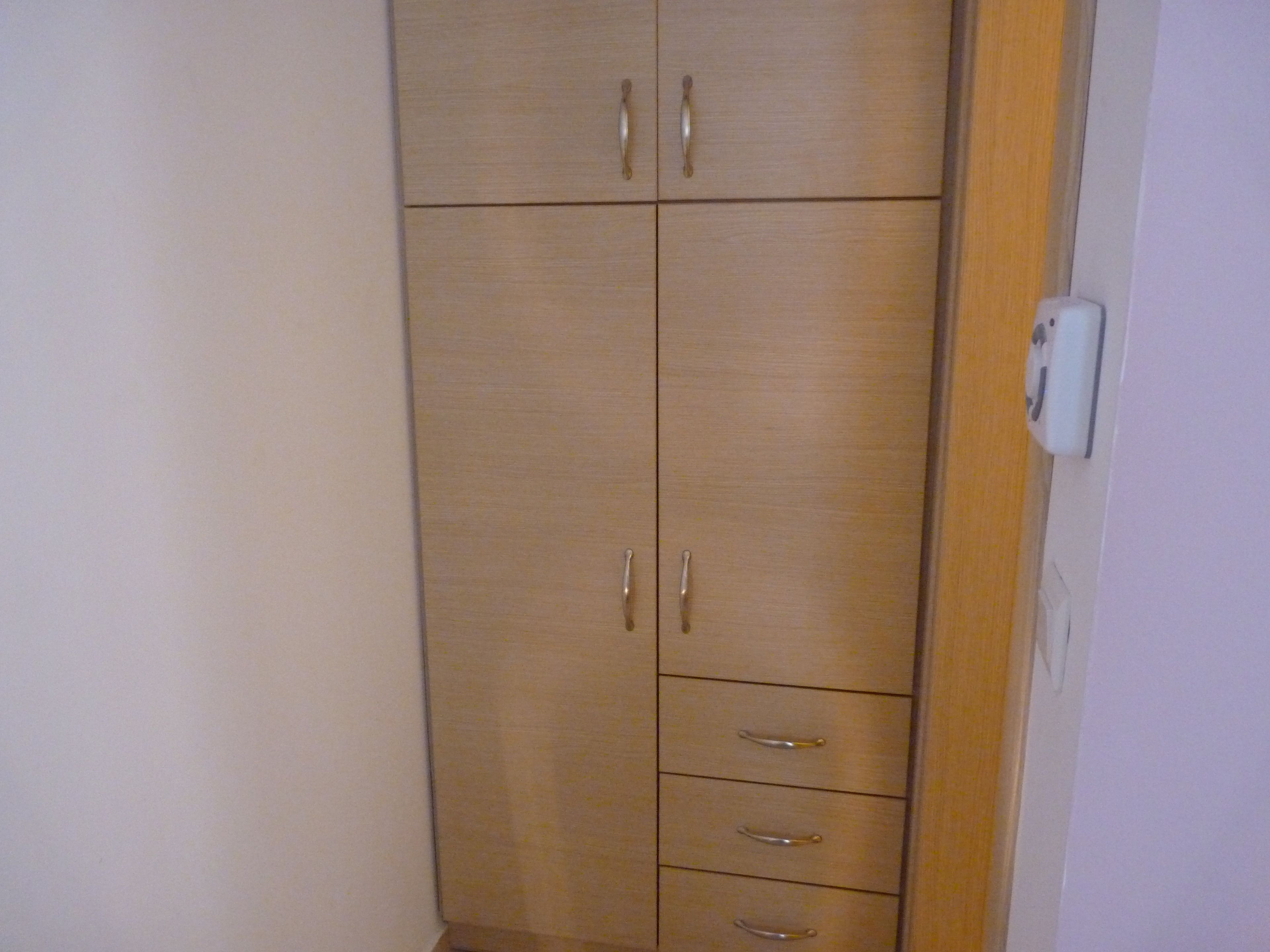 Un armario de madera con dos puertas y tres cajones.