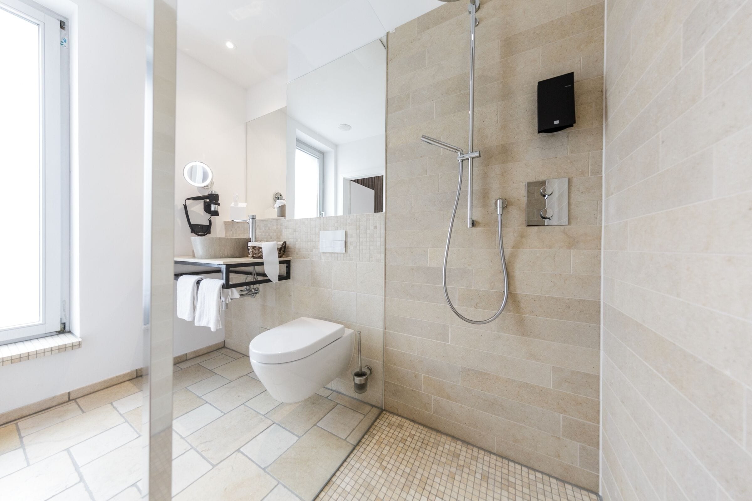 A modern bathroom with a shower, toilet, and sink.