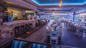 En rymlig restaurang med en bardel, flera olika typer av sittplatser och utsikt över omgivningen.