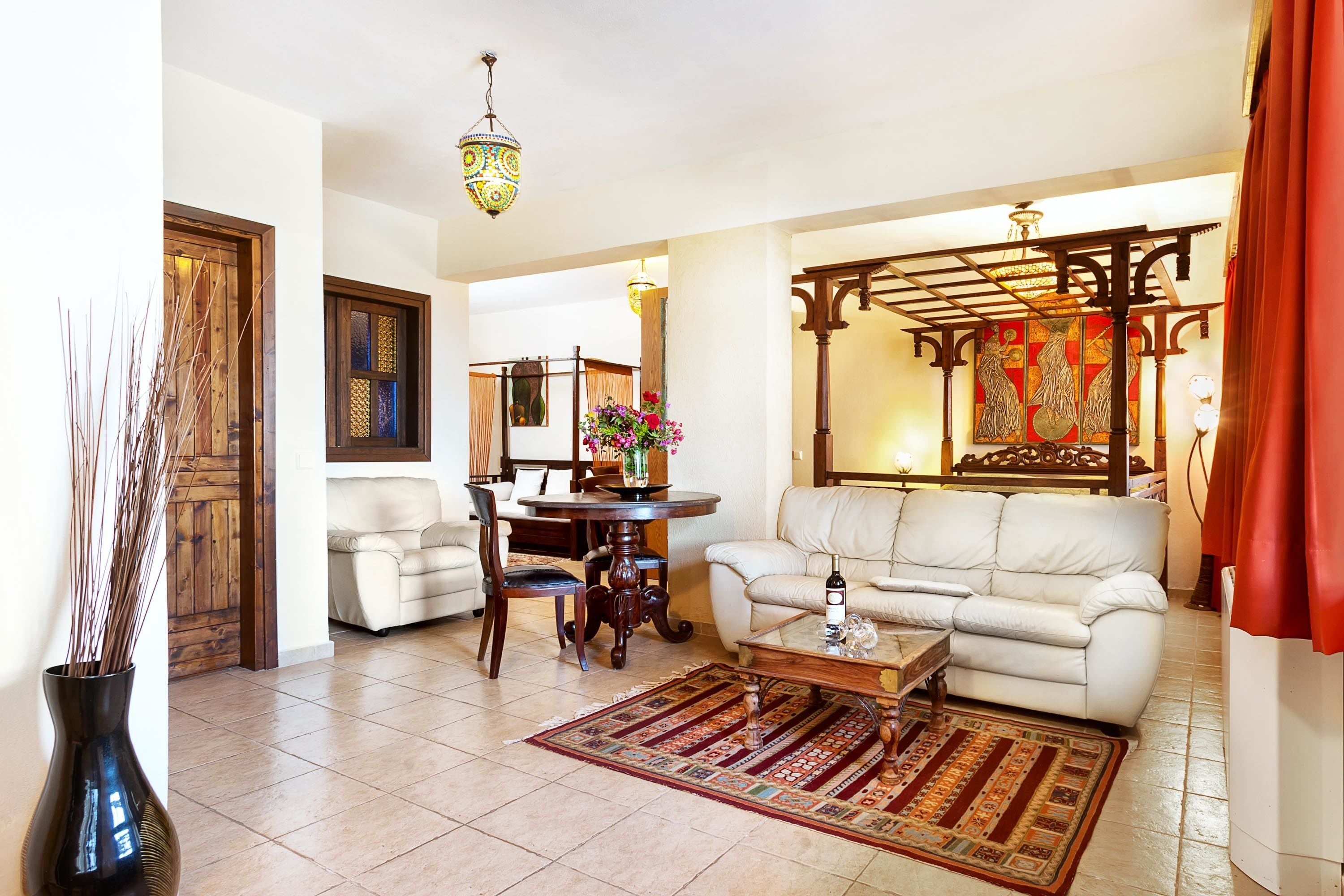 A living room with a sofa, coffee table, and a dining table with chairs.