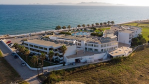 A coastal hotel with multiple buildings, a swimming pool, and a parking area. - Kos Palace Hotel (Kos)