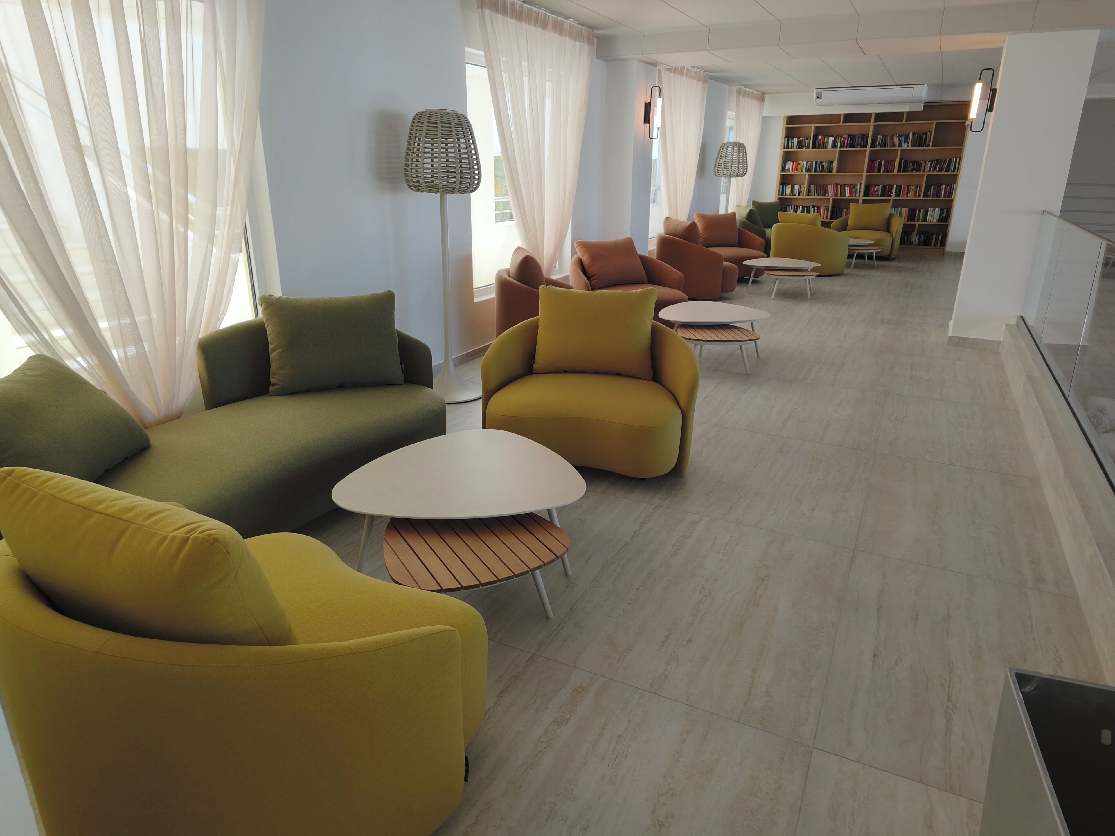 Un área de estar moderna con sofás, una mesa de centro y una estantería.