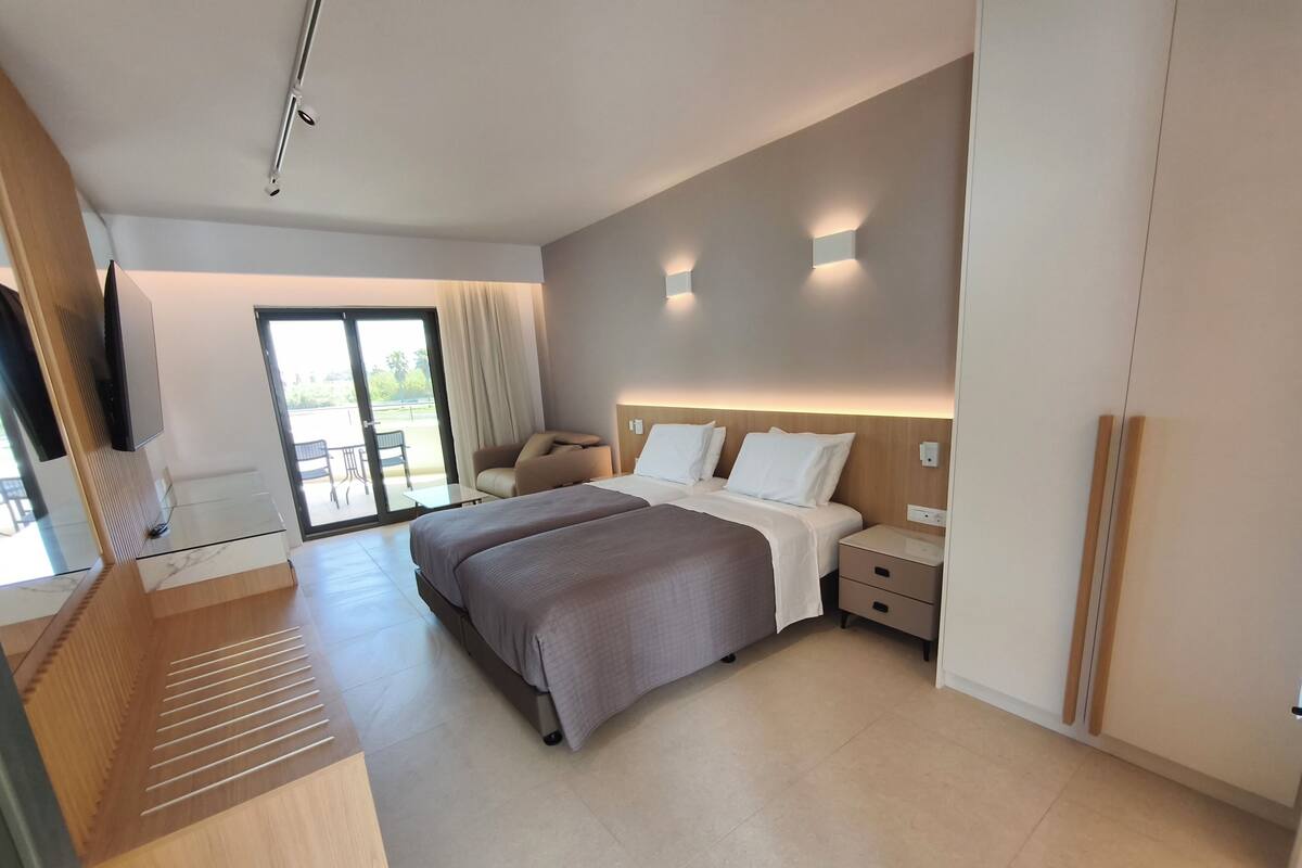 Una habitación de hotel moderna con una cama grande, un escritorio y vistas al exterior.