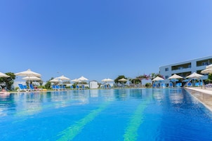 Una piscina al aire libre de temporada, sombrillas, tumbonas