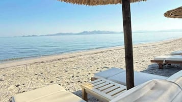 Accommodatie ligt op het strand, ligstoelen, parasols