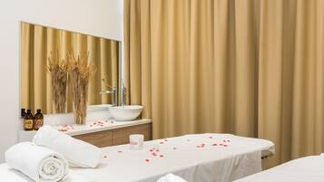 Een hotelkamer met een bed, een grote spiegel, een wastafel en een flesje lotion op het aanrecht.
