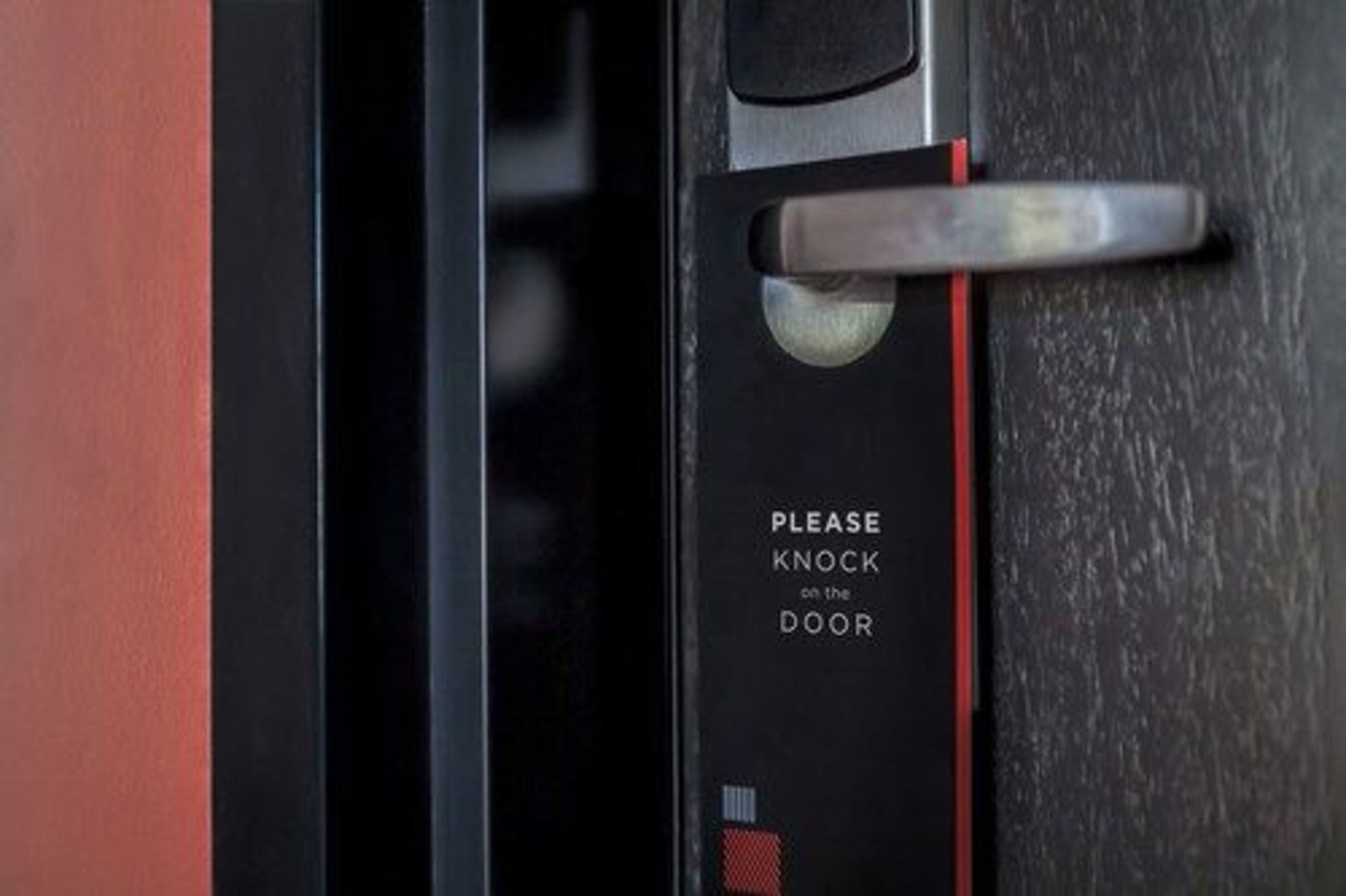 A door with a sign that says "PLEASE KNOCK on the DOOR."