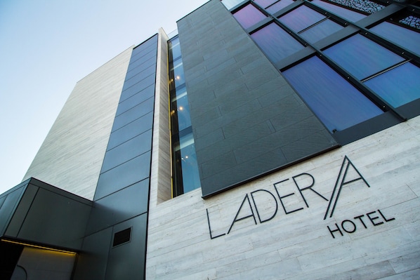 The Ladera Hotel features a modern architectural design with a combination of glass and concrete elements.