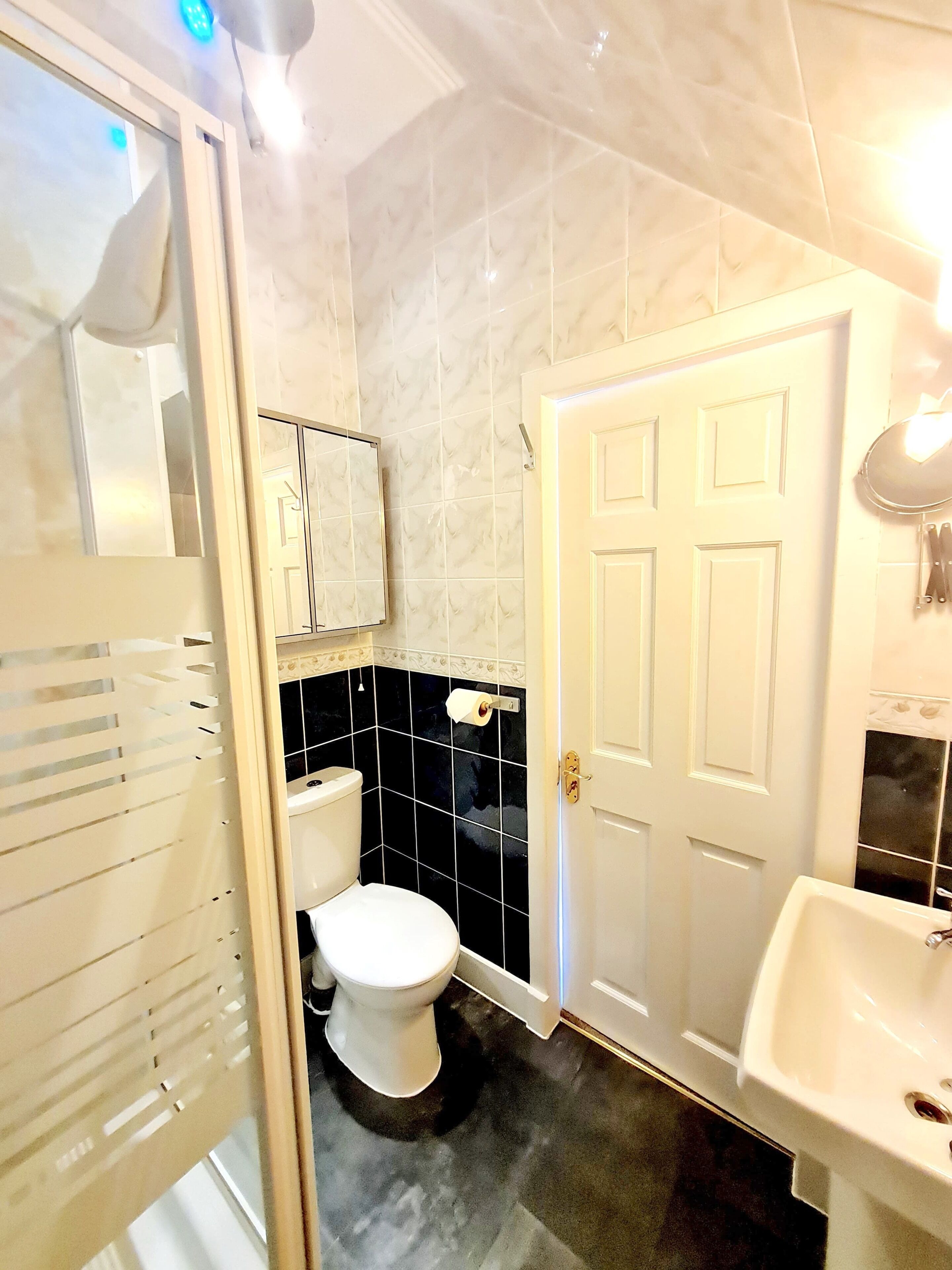 A bathroom with a toilet, sink, and mirror.