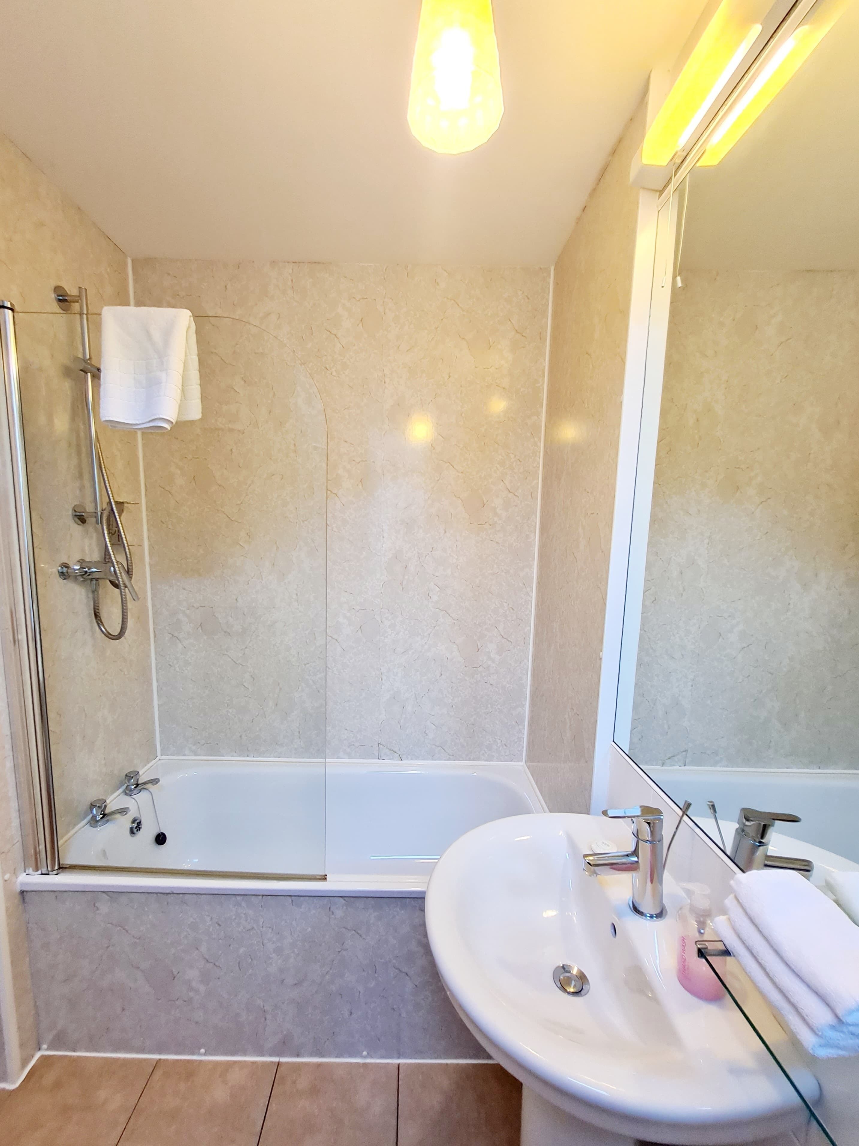 A modern bathroom with a bathtub, a sink, and a shower.
