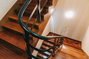 Una escalera de madera con barandilla de metal negro.