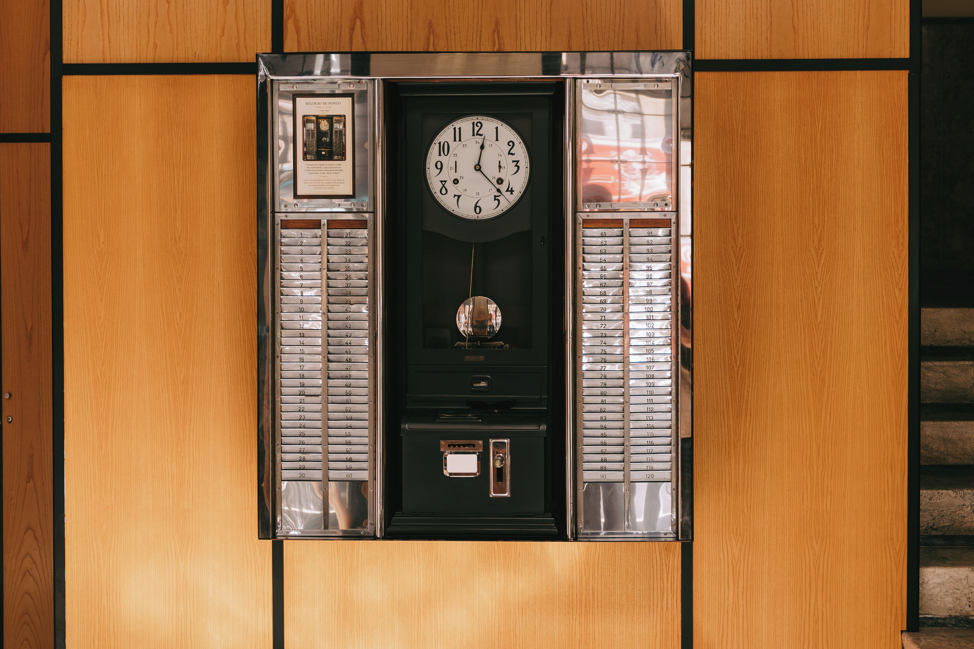Un ascensor de pared con reloj, botones de emergencia y un certificado enmarcado.