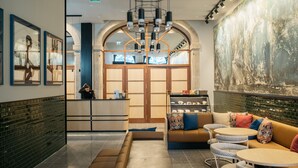 Een modern interieur met een receptiebalie, een zithoek en een muurschildering.