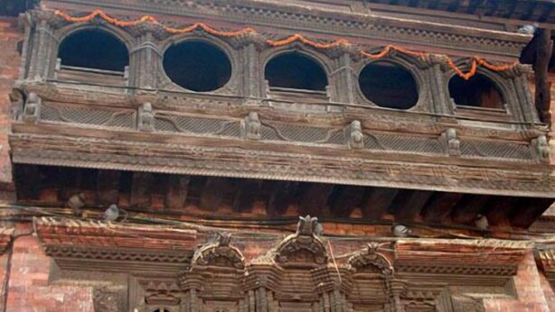 A multi-story building with ornate architectural details, including circular windows and decorative carvings. - Heirtage Inn Guest House (Bhaktapur)