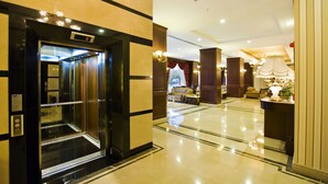 An elevator with a digital display, a lobby with a sofa and a lamp, and a reception desk. - Latanya Palm & Spa Airport Antalya (Antalya)