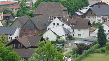 Un quartier résidentiel composé de différentes maisons, dont certaines sont équipées de panneaux solaires, et entouré de verdure.