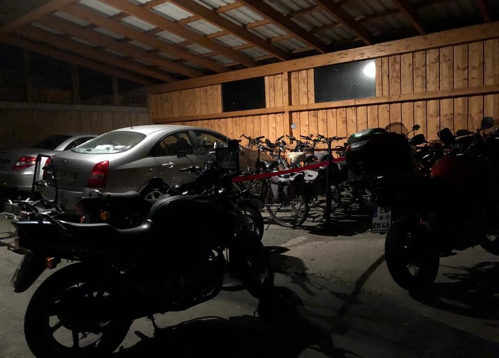 A garage with a car and motorcycles parked inside.