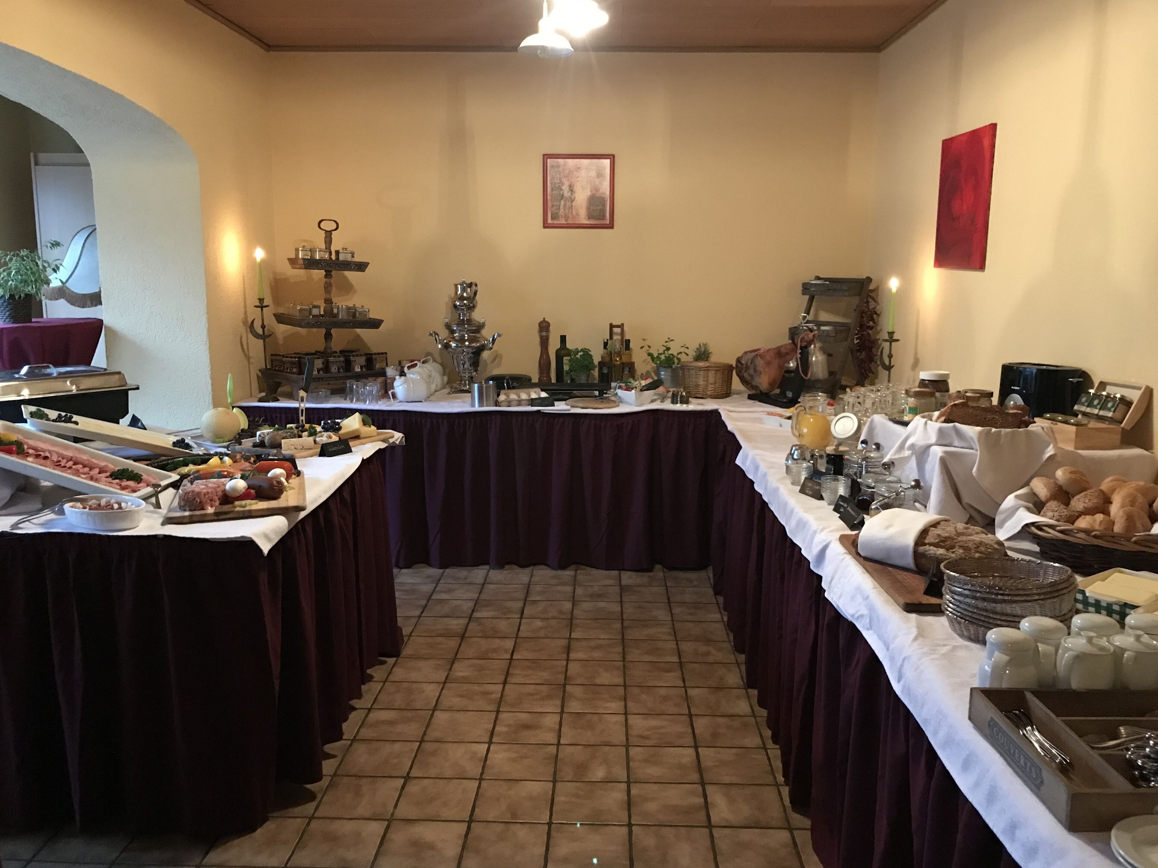 A buffet setup with various food items and a large decorative urn.