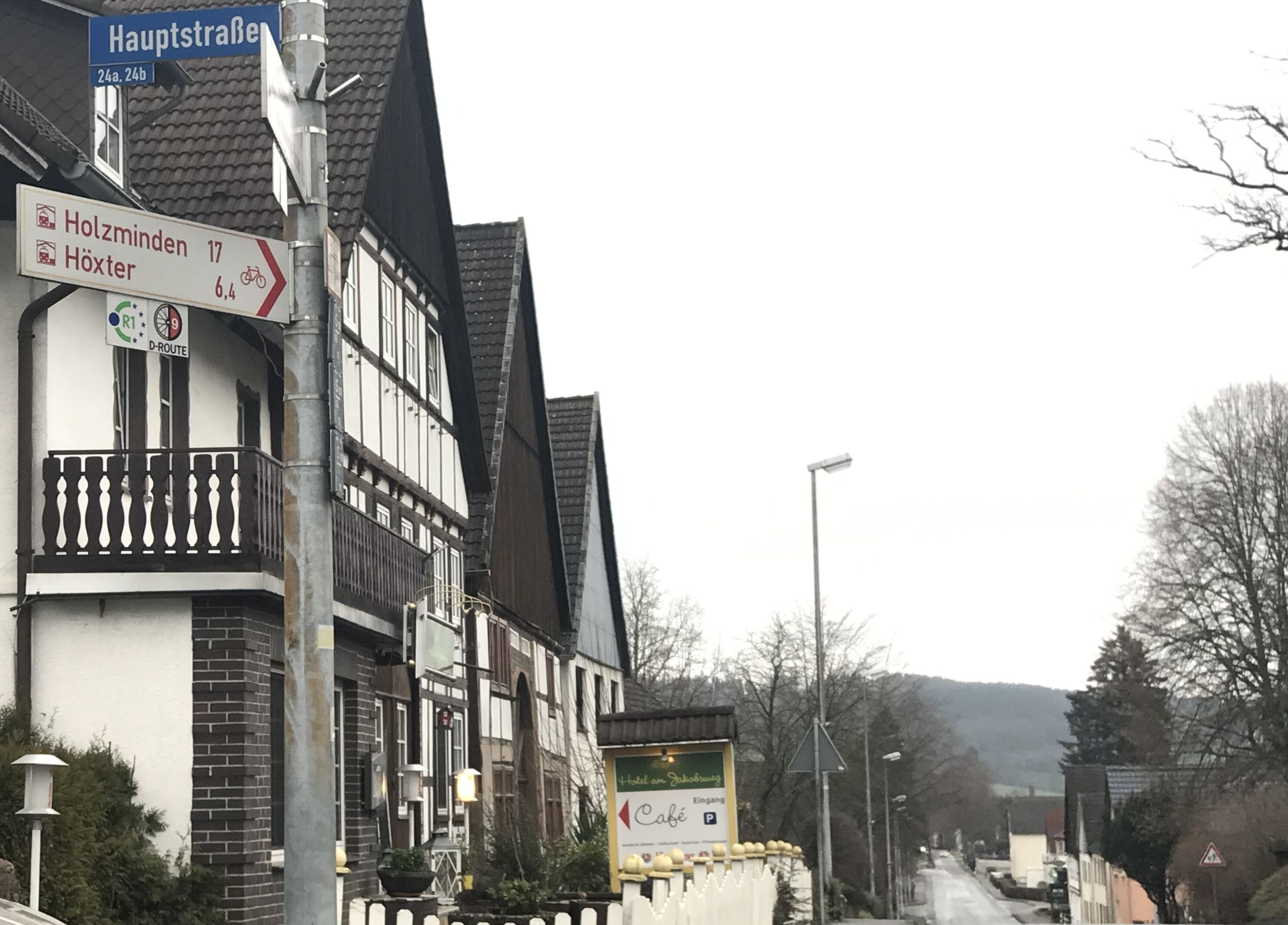 Um edifício europeu tradicional com uma placa indicando direções para Holzminden e Höxter.