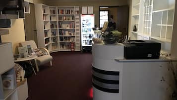 Eine Bibliothek mit Bücherregalen, einem Empfangstresen und einem Feuerlöscher.