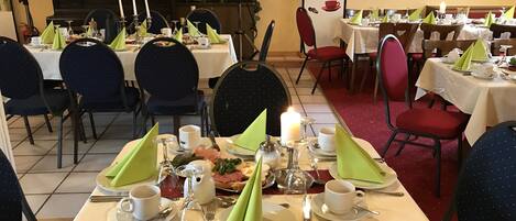 A restaurant with tables set for dining, featuring a menu board with coffee and espresso options.
