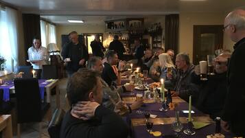 Un gruppo di persone sedute attorno a un tavolo in un ristorante, con candele e bevande.