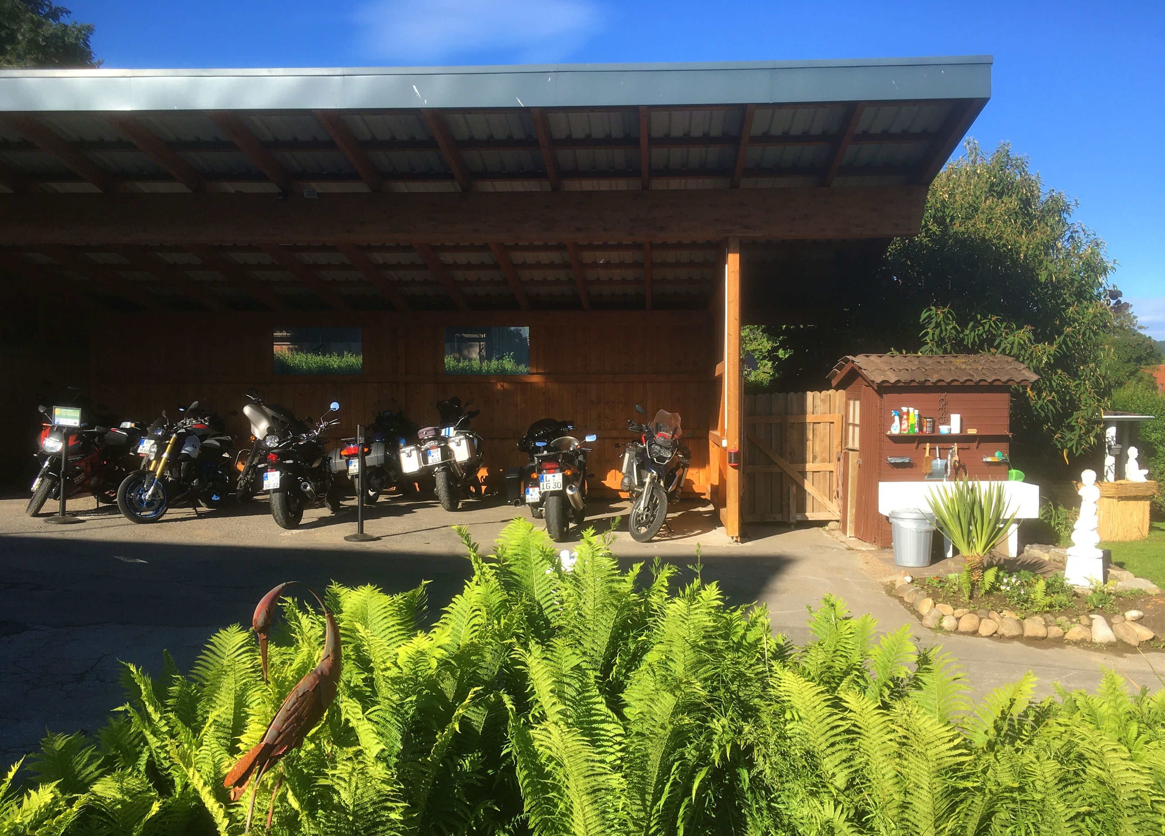 Un área de estacionamiento techada con varias motocicletas aparcadas bajo un techo.