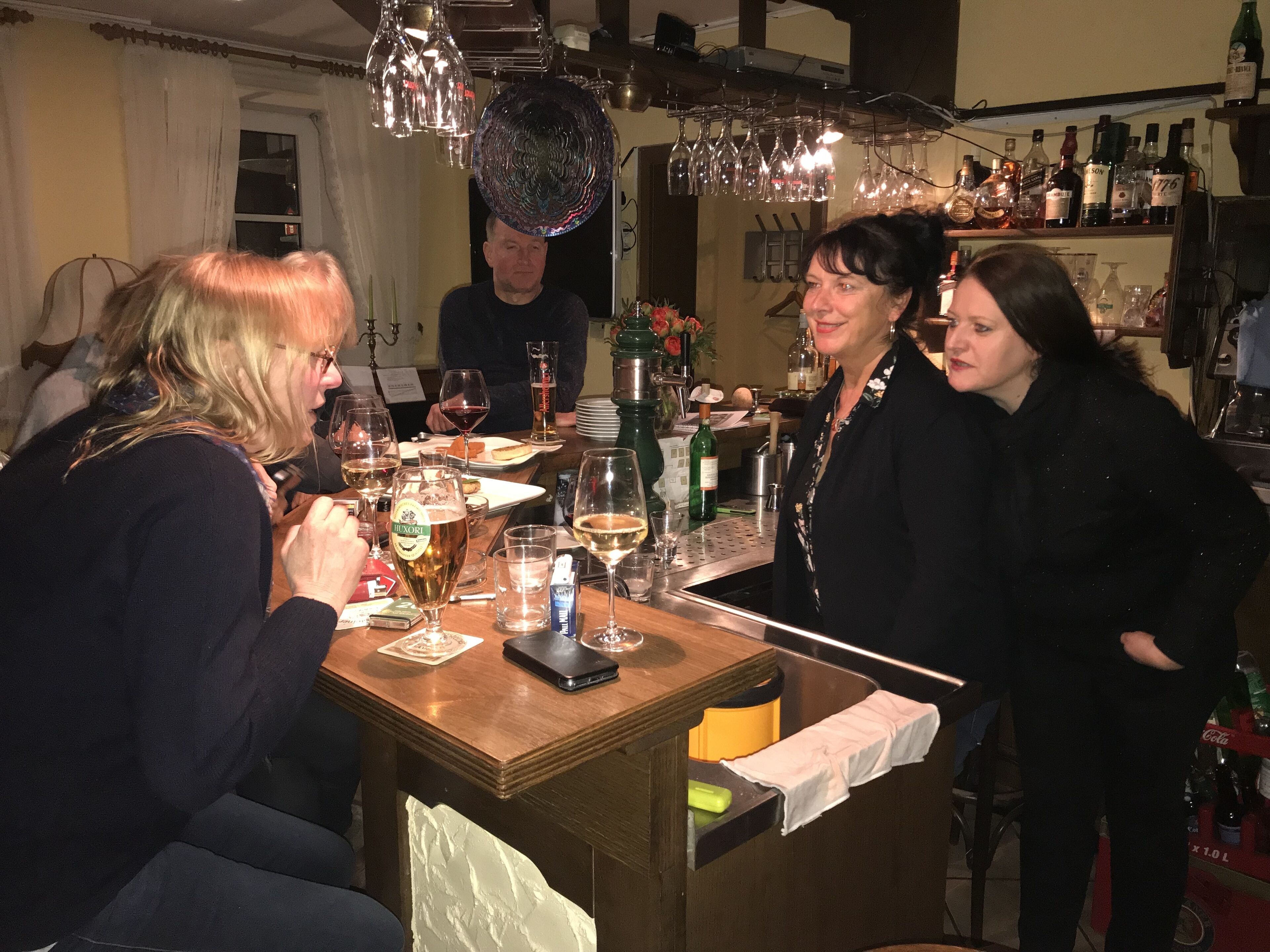 Un'area bar con un bancone, bicchieri, bottiglie e un menu.